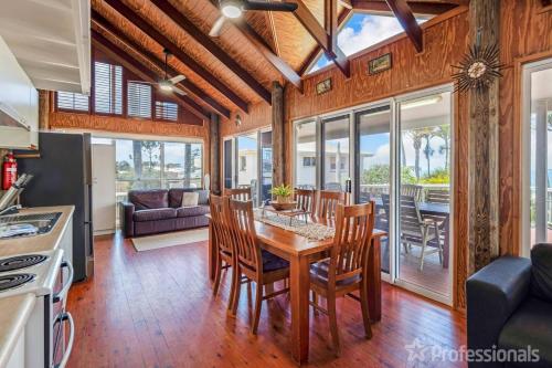 a kitchen and dining room with a table and chairs at Beachfront Holiday House in Zilzie