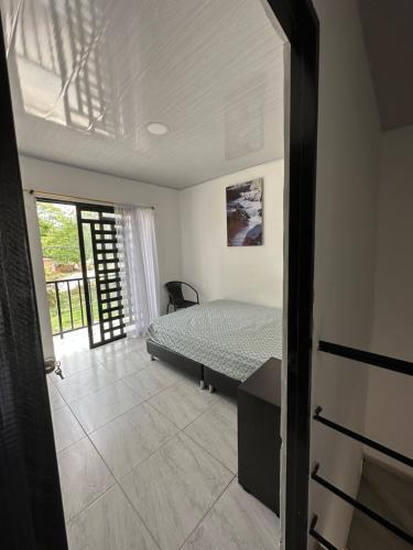 1 dormitorio con 1 cama en una habitación con ventana en Alojamiento en Neiva en Santa Rosalía de Guagua