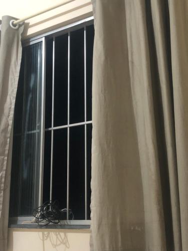 uma janela com barras num quarto em SamazzHouse em Guanambi