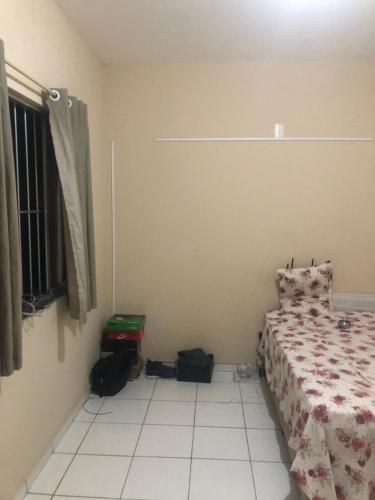 um quarto com uma cama e uma janela em SamazzHouse em Guanambi