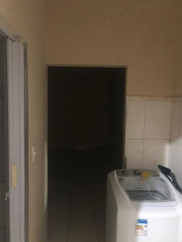 Habitación con puerta negra y nevera blanca. en SamazzHouse, en Guanambi