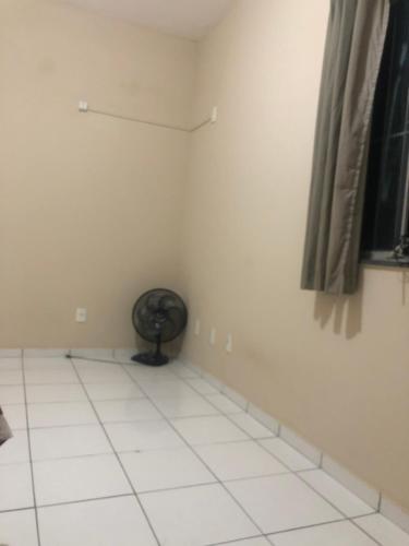 um quarto com piso em azulejo branco e uma ventoinha em SamazzHouse em Guanambi