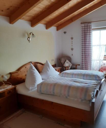 a bedroom with a large bed with a wooden headboard at Haus Stoaröserl in Schönau am Königssee