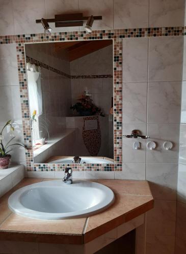 a bathroom with a sink and a large mirror at Haus Stoaröserl in Schönau am Königssee