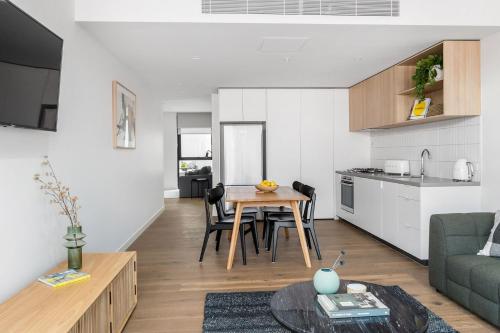 uma sala de estar e cozinha com mesa e cadeiras em Boutique Stays - Axel Apartments G02 The Faircroft em Melbourne