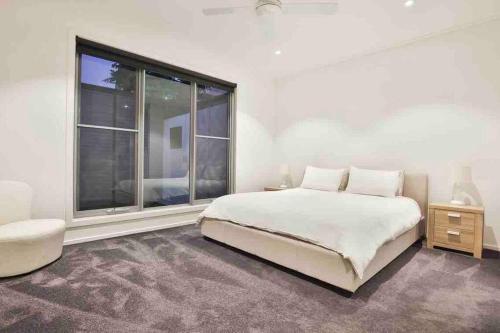 a bedroom with a bed and a large window at Inner City Stay Mildura in Mildura