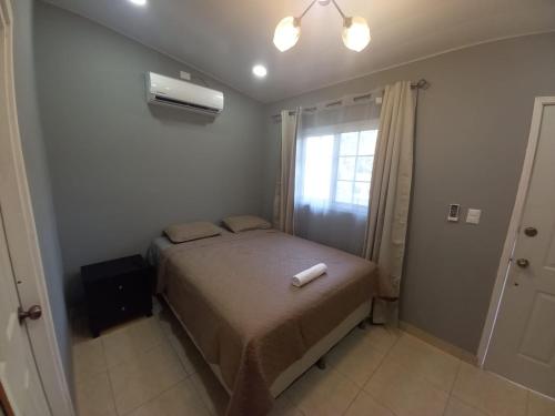 a small bedroom with a bed and a window at Palmerola Inn in Comayagua