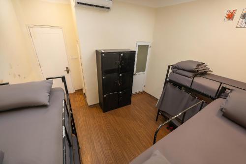 a room with two beds and a dresser in it at Queen Cafe Hotel & Pub in Hanoi