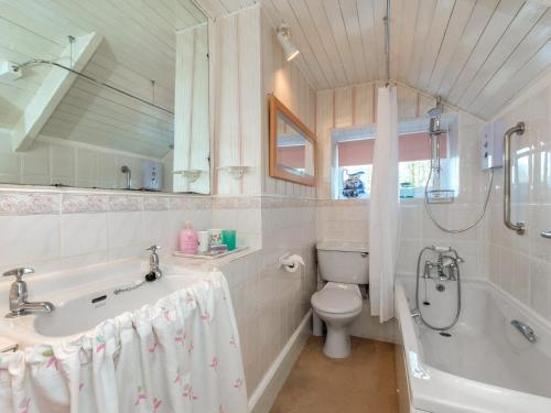 a bathroom with a tub and a toilet and a sink at Llys Isaf in Saint Nicholas