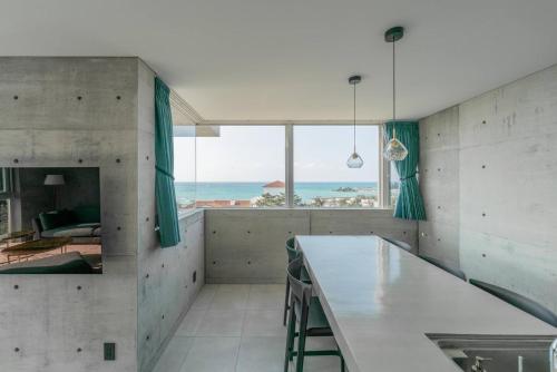 a kitchen with a table and a view of the ocean at Okinawa Plaisant Villa in Nakadomari