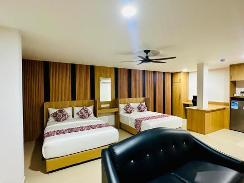 a room with two beds and a couch in it at Cozy Hotel@ KL Sentral in Kuala Lumpur