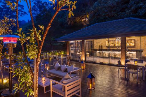 a patio with couches and tables and a building at The Golden Ridge Hotel in Nuwara Eliya