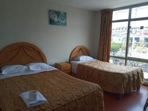 una camera d'albergo con due letti e una finestra di HOSPEDAJE AREQUIPA ANDINO ad Arequipa
