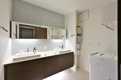 a bathroom with two sinks and a mirror at GRAND BASE Hiroshima Peace Memorial Park in Hiroshima