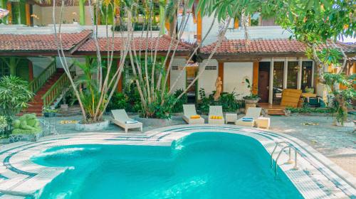 a swimming pool in front of a building with a house at BS Home in Kuta