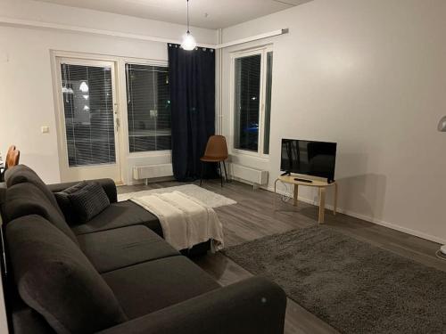 Apartment Korsholma1 في فاسا: غرفة معيشة مع أريكة وتلفزيون بشاشة مسطحة