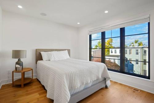 a white bedroom with a bed and a large window at Central DC Home+Private Rooftop! (Unit B) in Washington, D.C.