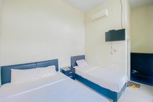 a small room with two beds in it at RedDoorz Syariah near Universitas Muhammadiyah Jember in Jember