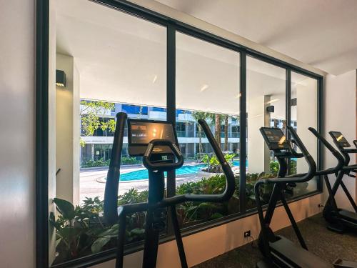 a gym with treadmills and a view of a pool at La Green Hotel and Residence in Bang Tao Beach