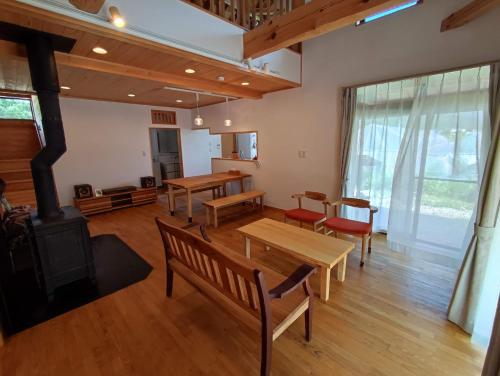 a living room with wooden furniture and a fireplace at Kikori House｜本物の素材にこだわった山村の一軒家 in Minamiaizu