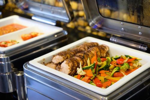 a tray of food with meat and vegetables at Hotel Clover Asoke - SHA Extra Plus in Bangkok