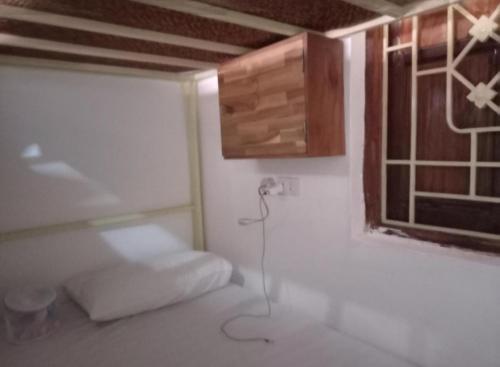 a room with a bed and a window at Watthat & Maladreds GUESTHOUSE dorm 1 in Luang Prabang