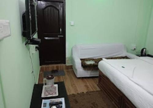 a room with a bed and a table in front of a door at TK Residency Arunachal Pradesh in Tawang