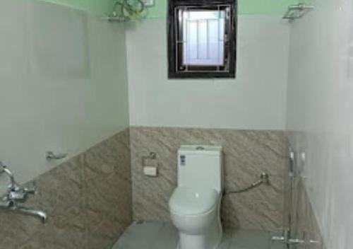 a bathroom with a toilet and a mirror at TK Residency Arunachal Pradesh in Tawang