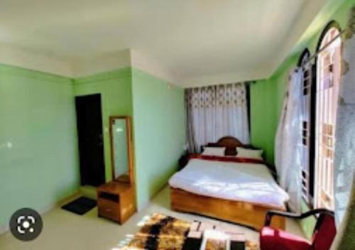 a green bedroom with a bed and a chair at TK Residency Arunachal Pradesh in Tawang