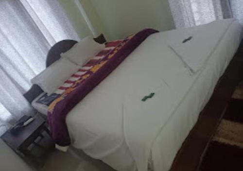 een wit bed in een kamer met een raam bij TK Residency Arunachal Pradesh in Tawang