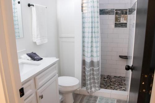 a white bathroom with a toilet and a shower at Hyde Park Haven - your home away from home - minutes north of Logan and USU in Hyde Park