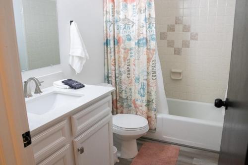 a bathroom with a toilet and a sink and a shower curtain at Hyde Park Haven - your home away from home - minutes north of Logan and USU in Hyde Park