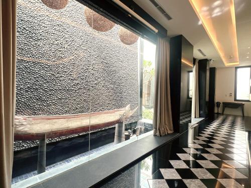 a lobby with a large stone wall with a bench at Orient Luxury Villa Motel in Huwei