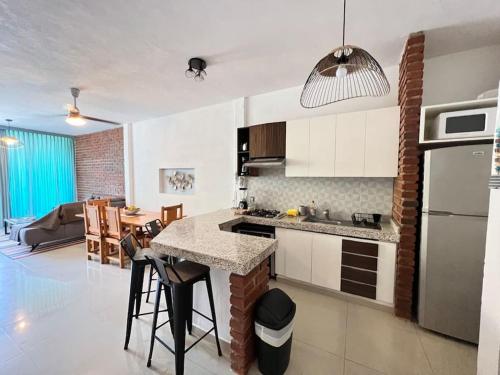 a kitchen and living room with a table and chairs at Chacala Corales para 7 con Aire Acondicionado con Alberca y Playa a 50 mts in Chacala