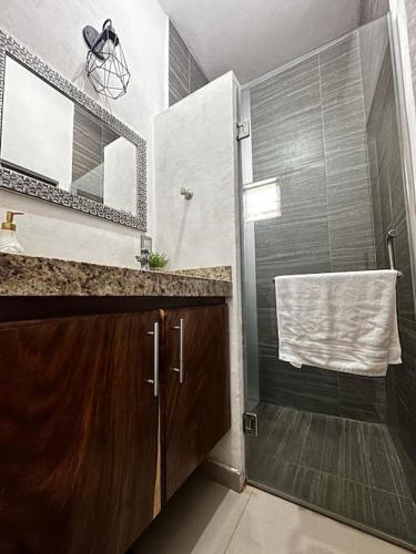 a bathroom with a shower and a sink and a mirror at Chacala Corales para 7 con Aire Acondicionado con Alberca y Playa a 50 mts in Chacala