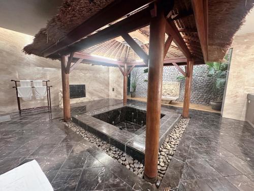 an outdoor shower in a room with a stone floor at Orient Luxury Villa Motel in Huwei