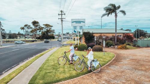 two people standing with bikes on the side of the road at Harbourview House in Bermagui