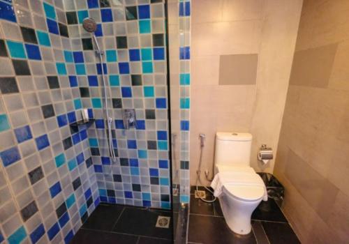 ein Bad mit einem WC und einer Dusche mit blauen Fliesen in der Unterkunft Mad Monkey Phuket in Patong Beach
