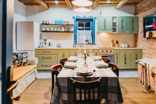 a kitchen with green cabinets and a table with chairs at Emese Guesthause in Şiclod