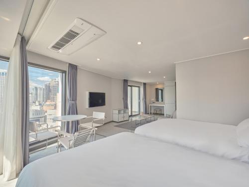a hotel room with two beds and a balcony at Y Collection by UH FLAT Haeundae beach in Busan