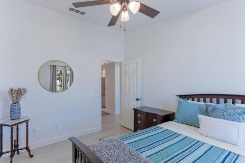 Un dormitorio con una cama y un ventilador de techo. en Sunset Paradise . Pool . BBQ . Smart TV . Sleeps10, en Lake Havasu City