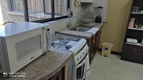 cocina con fregadero y fogones horno superior en Departamento Frente a la Plaza Sucre de Tarija, wifi, ascensor, garaje extra, en Tarija