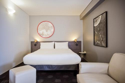 モントルイユにあるibis Styles Paris Mairie de Montreuilのベッド1台と椅子2脚が備わるホテルルームです。