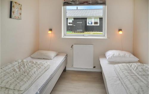 two beds in a small room with a window at Awesome Home In Ansager With Sauna, Wifi And Indoor Swimming Pool in Ansager