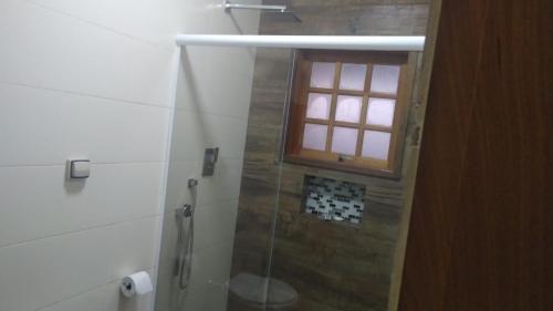 y baño con ducha acristalada y ventana. en Cantinho da Milla, en Itu