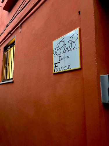 a sign on the side of a building that says back dance formed at B&B Donna Francé in Corbara
