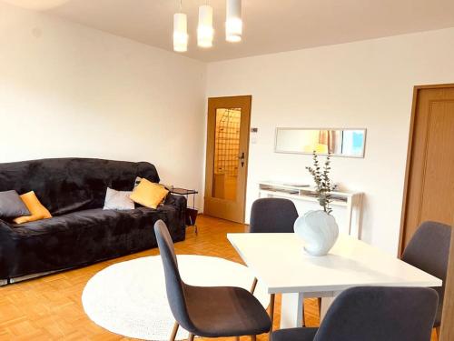 a living room with a black couch and a table at Ferienwohnung zum Wohlfühlen in Gmunden