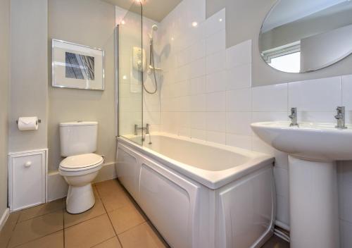 a white bathroom with a sink and a toilet at 4 Ynys Fawr in Abersoch