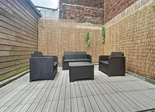 four wicker chairs and a table on a patio at T2 - parking et jardin privatif in Lambersart