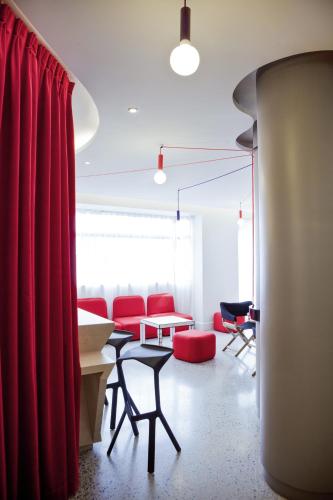 a living room with red furniture and a red curtain at ibis Styles Paris Mairie de Montreuil in Montreuil